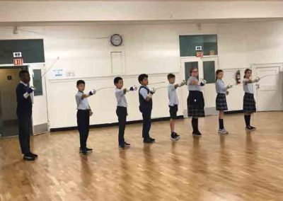 Students learning fencing in the school gym